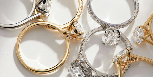 Yellow Gold, rose gold, white gold and silver rings with diamonds on a light background on a surface
