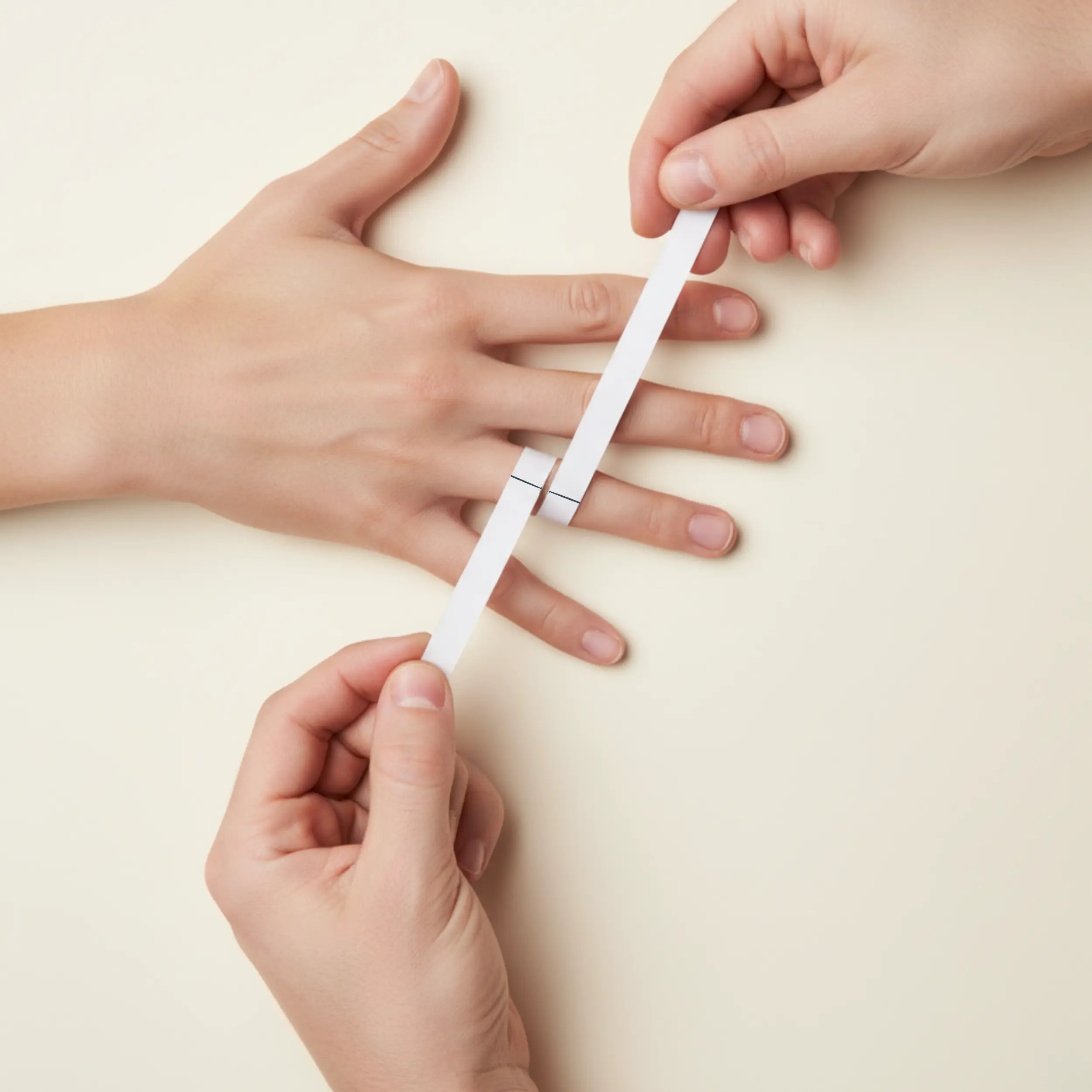 Hand with string wrapped around finger to measure circumference